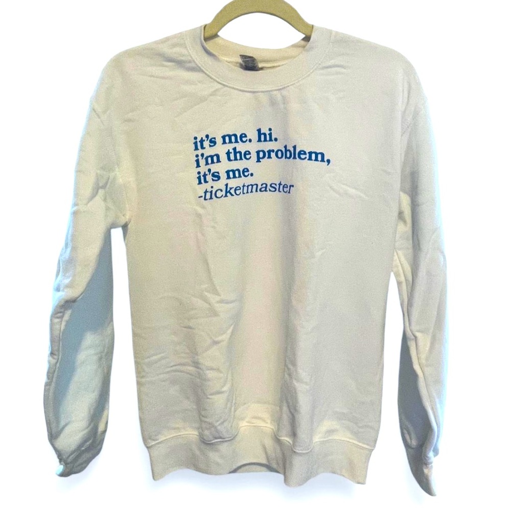 White and blue "It's me, hi, l'm the problem, it's me" ticketmaster sweatshirt
